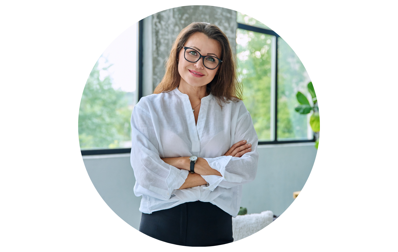 Eine junge Psychotherapeutin steht in ihrer Praxis und schaut freundlich und kompetent in die Kamera